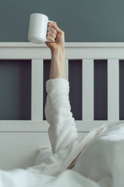 İlk sabah kahvesi. Tanınmayan bir adam uyanır ve elinde bir fincan kokulu kahveyle rahat bir yatakta uzanır. Olumlu duygular. İyi uykular. Güne başlarken.