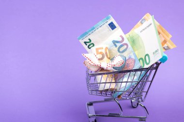 Avro banknotları, süpermarket tramvayında beyaz kurdele, mor arka planda izole edilmiş.
