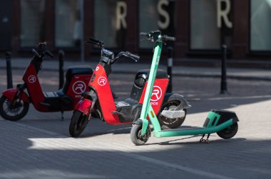 Riga, Letonya - 02 Nisan 2022 Bolt ve Ride elektrikli scooter 'ları Riga' daki eski bir kaldırımda park halindeler.