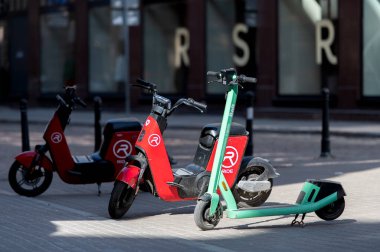 Riga, Letonya - 02 Nisan 2022 Bolt ve Ride elektrikli scooter 'ları Riga' daki eski bir kaldırımda park halindeler.