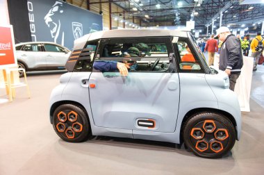 Riga, Letonya - 29 Nisan 2022: İnsanlar Fransa 'nın küçük Citroen Ami elektrikli iki koltuklu mikro-şehir arabasının keyfini çıkarıyorlar .