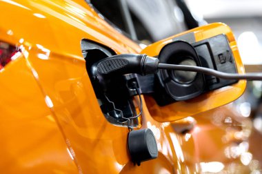 Modern bir elektrikli arabaya takılan güç kaynağının yakınlaştırılması. Elektrik veya EV araba şarj istasyonu.