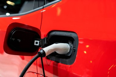 Modern bir elektrikli arabaya takılan güç kaynağının yakınlaştırılması. Elektrik veya EV araba şarj istasyonu.
