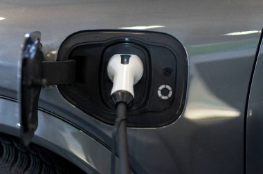 Modern bir elektrikli arabaya takılan güç kaynağının yakınlaştırılması. Elektrik veya EV araba şarj istasyonu.