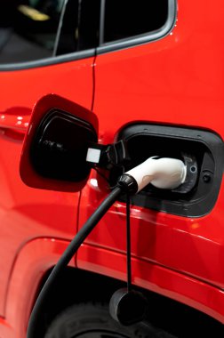 Modern bir elektrikli arabaya takılan güç kaynağının yakınlaştırılması. Elektrik veya EV araba şarj istasyonu.