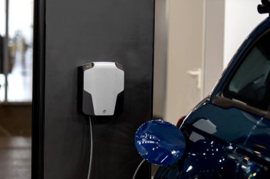 Modern bir elektrikli arabaya takılan güç kaynağının yakınlaştırılması. Elektrik veya EV araba şarj istasyonu.
