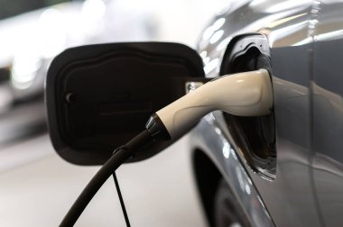 Modern bir elektrikli arabaya takılan güç kaynağının yakınlaştırılması. Elektrik veya EV araba şarj istasyonu.