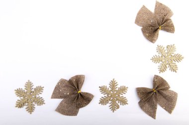 Çuval bezi yaylar altın parıltısı ve beyaz arka planda kar taneleri, Noel tatili dekoru