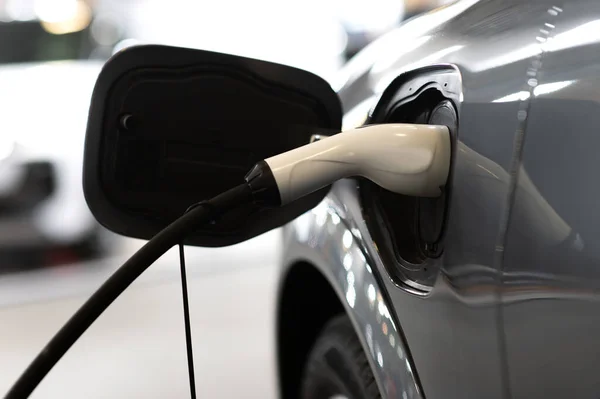 Stock image Closeup of power supply plugged into an modern electric car. Electric or EV car charging station.