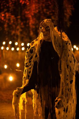 Karanlık bir cadılar bayramı gecesinde süpürge ve canavar suratlı bir cadı.