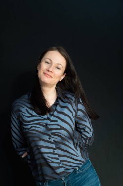 Siyah bir arkaplan üzerinde elleri olan çapkın bir esmerin portresi.