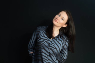 Siyah bir arkaplan üzerinde elleri olan çapkın bir esmerin portresi.