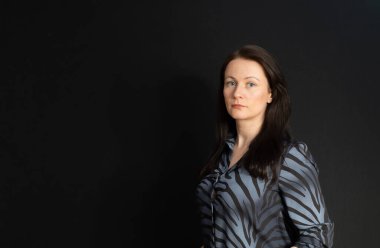 Karanlık bir stüdyoda esmer bir gencin portresi.