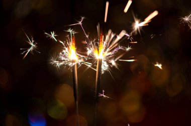 Bulanık bokeh arka planda parlak, yanan bir maytap.