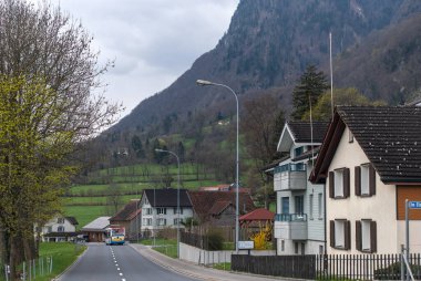 Sennwald, İsviçre 7 Nisan 2023 bir dağ köyü boyunca asfalt bir yol kıvrılır.