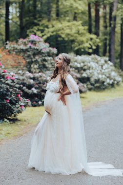 Şehvetli hamile kadın çiçek açan rhododendron parkında