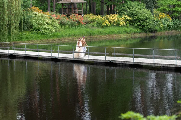 Romantyczna Ciężarna Para Spacerująca Drewnianym Moście Zielonej Kwitnącej Naturze — Zdjęcie stockowe