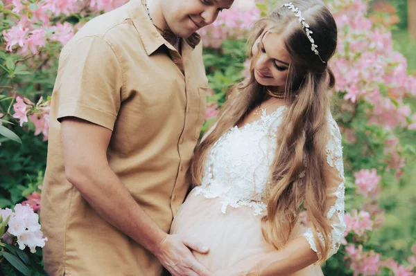 Glückliches Schwangeres Paar Das Sich Blühenden Garten Umarmt Künftige Eltern — Stockfoto