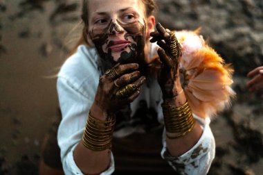 Yüzüne lüks takılar takmış kirli siyah elleri olan komik bir kadın. Neşeli duygular.