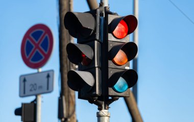 Şehir caddesinde kasvetli bir gökyüzüne karşı kırmızı trafik ışığı. Arabalar için semafor ışıkları. Mavi kasvetli gökyüzü ve konut binalarının arka planına karşı kırmızı trafik ışığı. Şehir altyapısı. Araç trafiğinin kuralları, cadde trafiği. Semap
