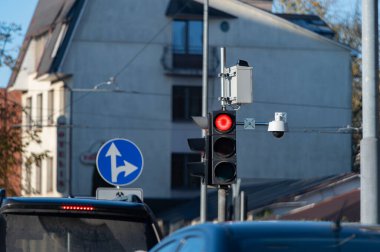 Şehir caddesinde kasvetli bir gökyüzüne karşı kırmızı trafik ışığı. Arabalar için semafor ışıkları. Mavi kasvetli gökyüzü ve konut binalarının arka planına karşı kırmızı trafik ışığı. Şehir altyapısı. Araç trafiğinin kuralları, cadde trafiği. Semap