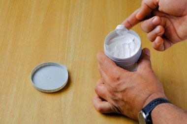 Basra, Irak - 07 Nisan 2023: Plastik kutudan merhemcilerin parmak izi alınırken çekilen fotoğraf