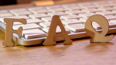 Faq kelime veya kavram ahşap arka planda ahşap harfler, sık sık sorulan sorular arka planda beyaz klavye ile kısaltma