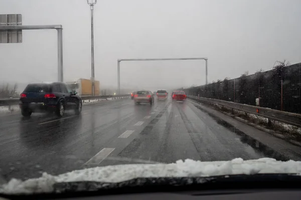 heavy snow during rush hour during snowy foggy winter day in Europe, carefully driving in bad weather condition