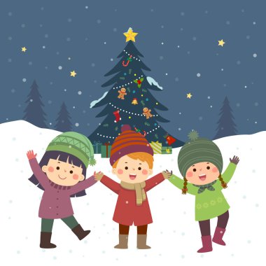 Mutlu çocuklar karların altında Noel ağacının yanında oynuyorlar..