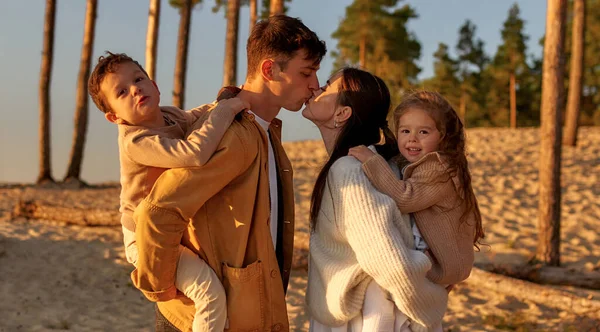 Eine Junge Familie Mit Zwei Kindern Auf Dem Rücken Küsst — Stockfoto