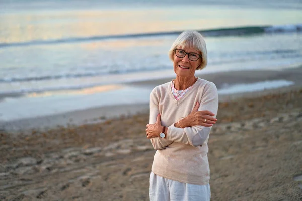 Пожилая Умная Женщина Очках Прогуливается Пляжу Моря Осенью Прохладную Погоду — стоковое фото