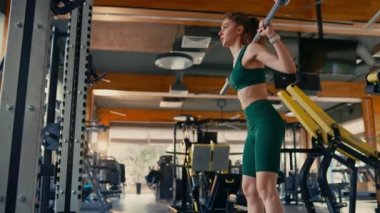 Spor giyimli zayıf atletik beyaz kadın spor salonunda kettlebell ile çömelme hareketi yapıyor. Spor ve eğlence kavramı..