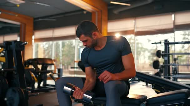 운동복 차림의 근육질 선수가 클럽에서 이두근을 운동을 스포츠와 오락이라는 — 비디오