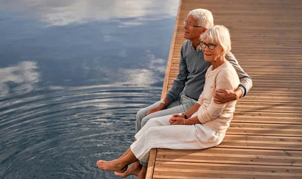海の港にある桟橋には 知的で白髪の老夫婦が座っており ロマンチックな時間を過ごしています — ストック写真