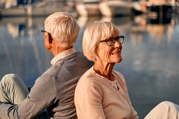 海の港にある桟橋には 知的で白髪の老夫婦が座っており ロマンチックな時間を過ごしています — ストック写真
