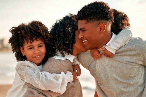 白いドレスを着たかわいい娘と背中の小さな息子を持つアフリカ系アメリカ人の家族が歩くと夜明けに海で砂浜で楽しみます — ストック写真