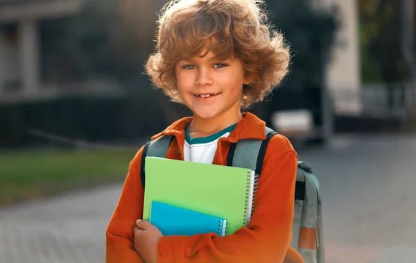 在街上 快乐可爱的聪明男孩 留着时髦的发型 手里拿着书包和笔记本 现代背包 第一次去学校 回学校去 — 图库照片