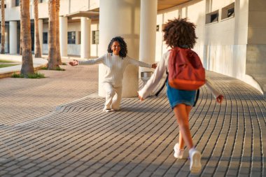 Mutlu Afrikalı Amerikalı anne, anaokulunun kızıyla tanışıyor. Ders bitmiştir. Sonbaharın ilk günü. Ebeveynlik, sevgi ve bağlantı kavramı.