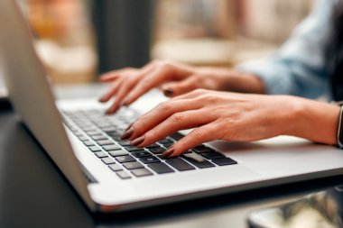 Cropped image of female hands typing on laptop computer working on freelance searching information in networks for online business. Student learning online.