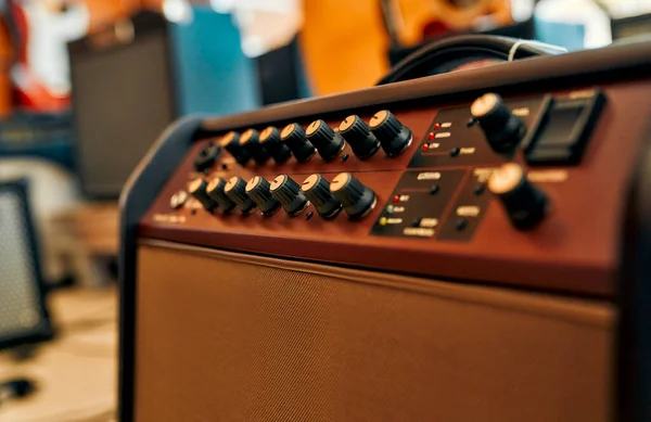 Close-up of an electric guitar combo amp in a musical instrument store. Lots of different musical instruments for sale. Hobbies and recreation.
