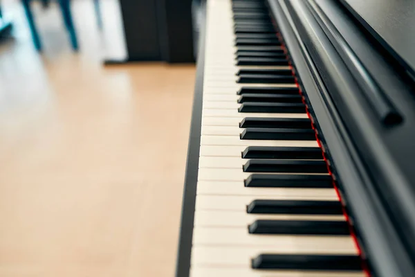 Close-up of black piano keys in a musical instrument store. Lots of different keyboard instruments for sale. Hobbies and recreation.