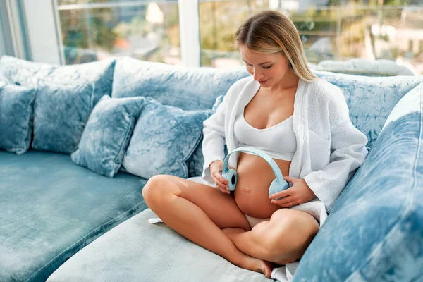 Una Joven Embarazada Con Abrigo Blanco Que Pone Auriculares Barriga —  Fotos de Stock