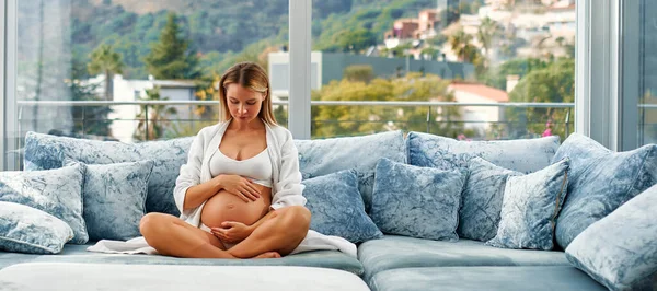 Young Pregnant Woman White Coat Her Hands Her Tummy Sitting — Stock Photo, Image