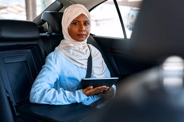 Młoda Muzułmanka Hidżabie Korzystająca Tabletu Podczas Siedzenia Samochodzie Muzułmańska Kobieta — Zdjęcie stockowe