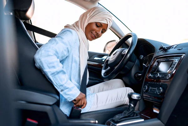 車の車輪の後ろに座っているヒジャーブの若いイスラム教徒の女性 車の購入とレンタル 旅行とレクリエーション — ストック写真