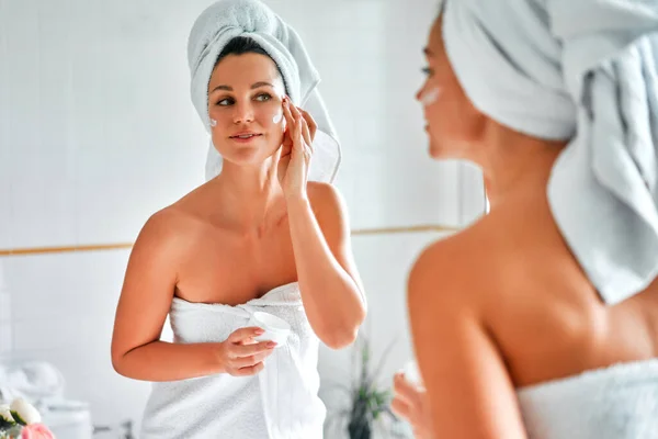 Mulher Bonita Uma Toalha Branca Lavatório Espelho Usando Creme Facial — Fotografia de Stock