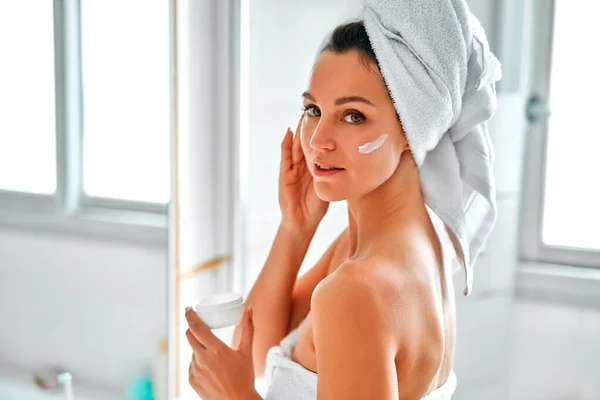 Mulher Bonita Uma Toalha Branca Lavatório Espelho Usando Creme Facial — Fotografia de Stock