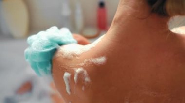 Güzel bir kadın köpük banyosunda uzanıyor, havluyla banyo yapıyor, eğleniyor ve dinleniyor. Sabah rutini. Kozmetoloji ve kaplıca prosedürleri.