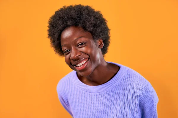 身穿蓝色毛衣的非洲裔美国女青年站在明亮的橙色背景下微笑着 — 图库照片