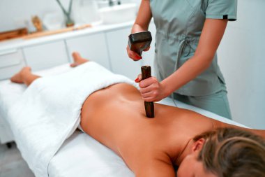 Geleneksel Tayland masajı tok-sen sırasında genç bir kadın, tahta aletlerle alternatif doğu tıbbı. Kuaförde vücut bakımı ve SPA.